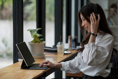 Young woman using laptop at table