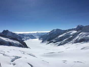 Scenic view of snowcapped mountains against clear blue sky