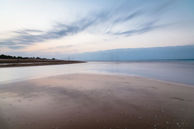 Scenic view of beach against sky during sunset