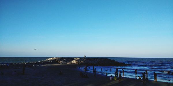 Scenic view of beach against clear blue sky