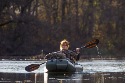 Portrait of young woman sailing inflatable raft on river