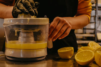 Midsection of woman squeezing lemons 