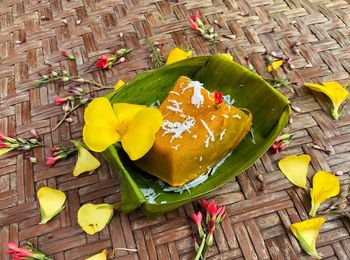 High angle view of fresh yellow flowers in basket on table