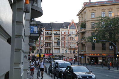 Vehicles on road by buildings in city