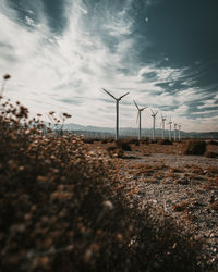 Wind turbines on land against sky