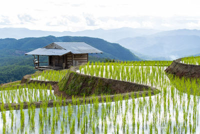 Built structure by lake against mountain range