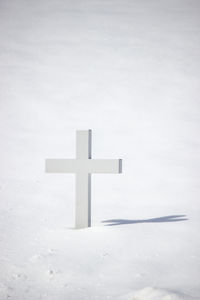 Cross on snow covered field