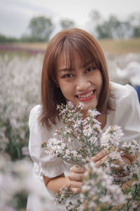Portrait of young woman holding flowers