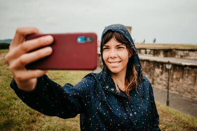 Smiling young woman using mobile phone