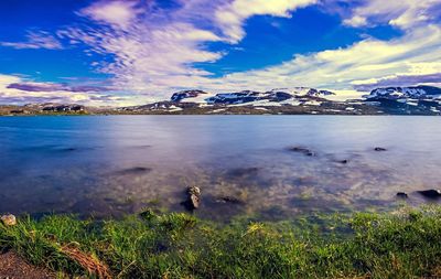 Scenic shot of calm lake against cloudy sky