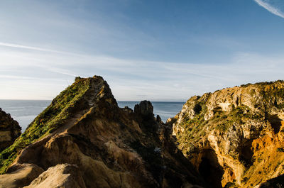 Panoramic view of rocks on beach against sky