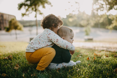 Rear view of mother and daughter on field