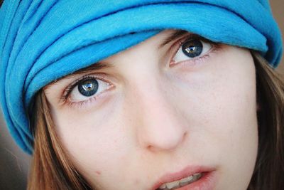 Close-up portrait of young woman with blue headscarf