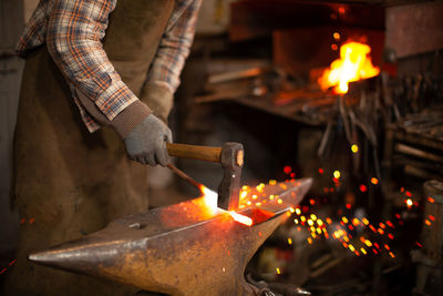 Midsection of man working with burning candles