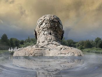 Rock formation on shore against sky