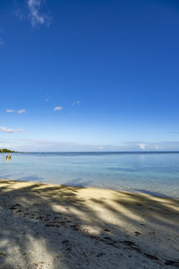 Scenic view of beach against blue sky