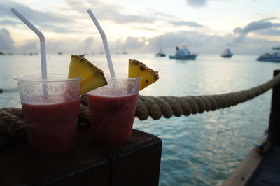 Close-up of cocktails on boat sailing in sea at sunset