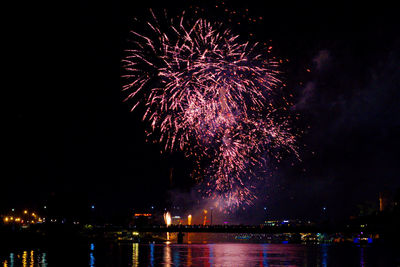 Firework display over river at night