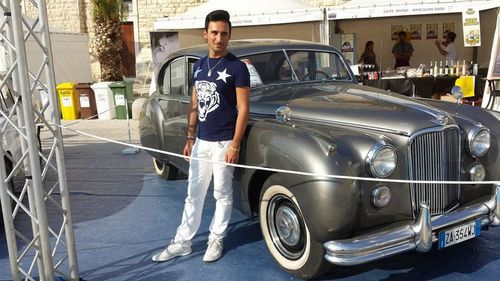 Portrait of young man standing in car