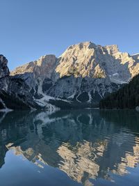 Scenic view of lake and mountains against clear blue sky