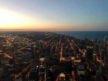 High angle view of city lit up at sunset