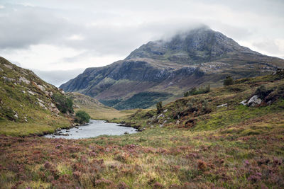 Scenic view of mountain range against cloudy sky