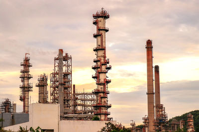 Stack of industry against sky during sunset