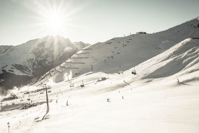 Sun shining over snow covered mountains