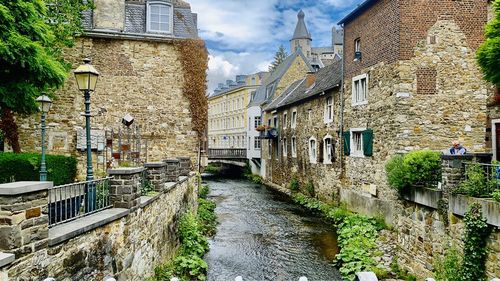 Canal amidst buildings in town against sky