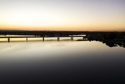 Scenic view of lake against clear sky during sunset