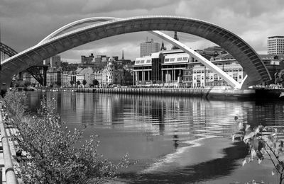 Reflection of bridge in water against sky