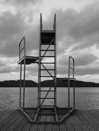 Springboard on wooden walkway against sky