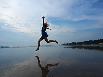 Full length of man jumping in sea against sky