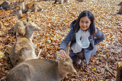 Portrait of smiling young woman during autumn leaves