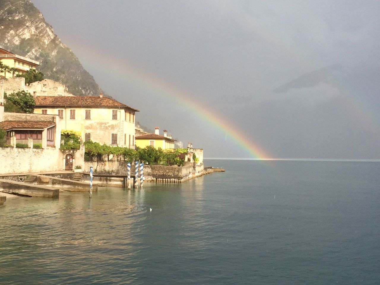 architecture, rainbow, building exterior, built structure, multi colored, water, beauty in nature, waterfront, scenics, town, colorful, river, double rainbow, nature, sky, day, cloud - sky, tranquility, natural phenomenon, majestic, tranquil scene, in front of, no people, sea