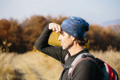 Mature man with backpack looking into the distance.