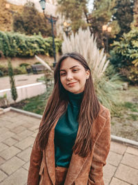 Portrait of smiling young woman standing outdoors