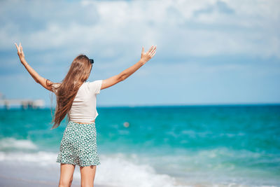 Rear view of woman standing at beach