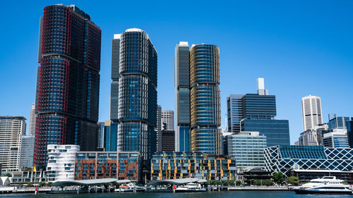 Modern buildings in city against blue sky