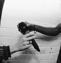 Midsection of man photographing against wall