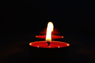 Close-up of lit candles against black background