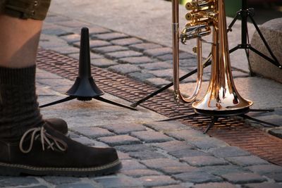 Low section of person with trumpet on footpath