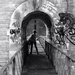 Low angle view of woman standing by railing