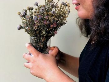 Midsection of woman holding flower bouquet