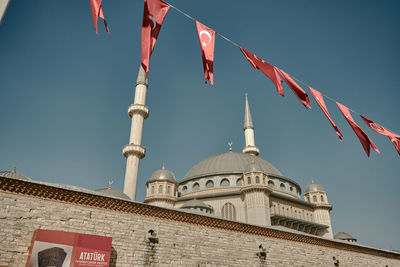 Low angle view of flags on building against sky