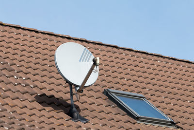 Satellite antenna on a red roof