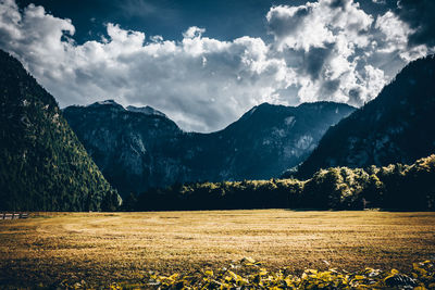 Scenic view of field and mountains against sky