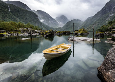 Boat moored on lake against mountains