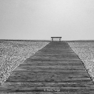 Boardwalk on beach against clear sky