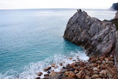 Rock formations on sea shore against sky